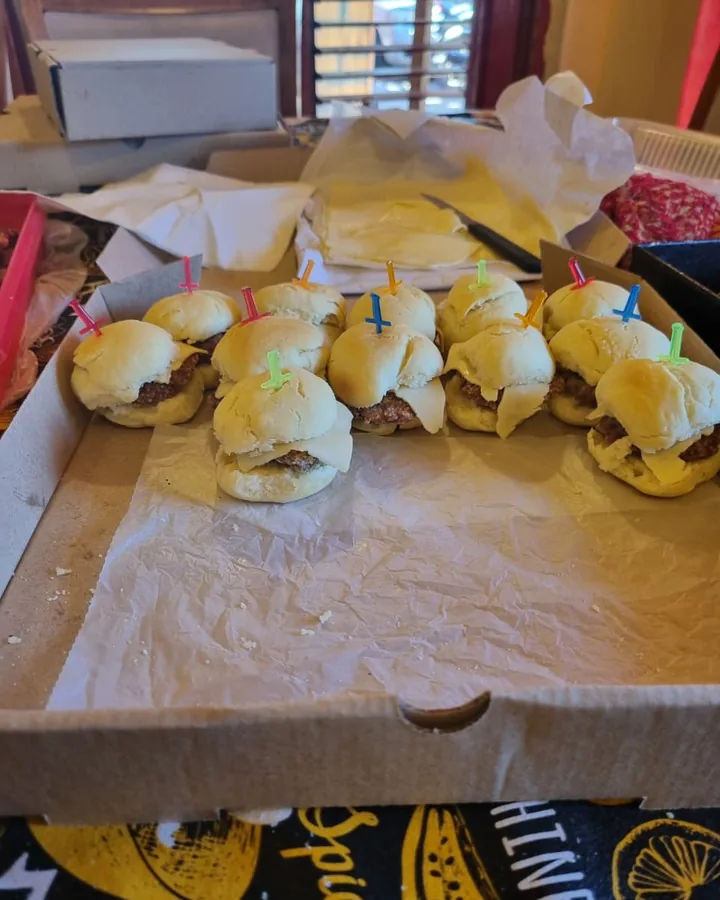 Mini hamburguesas con queso sobre papel manteca, listas para servir