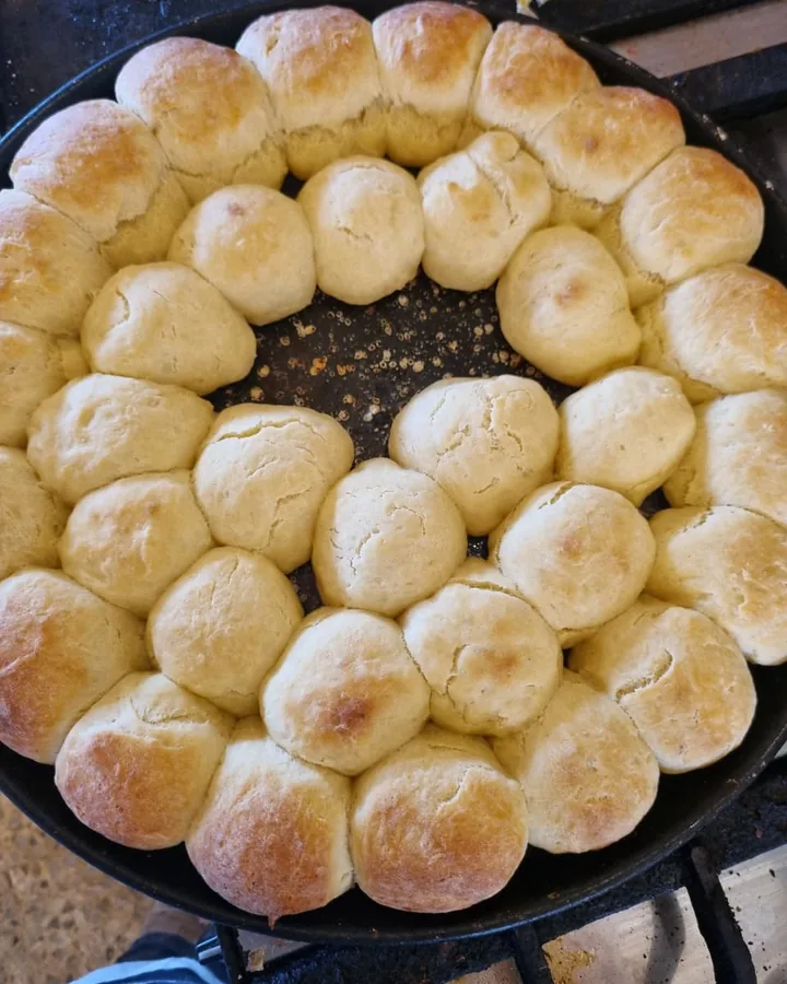 Pancitos caseros dorados recién salidos del horno en una sartén